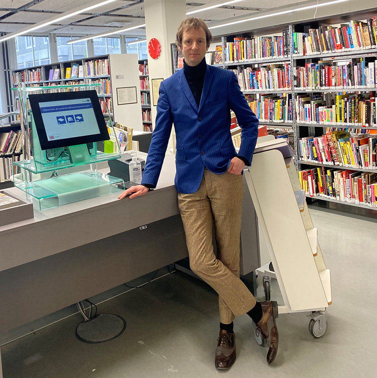 Välklädd bibliotekarie vid självbetjäningsautomat