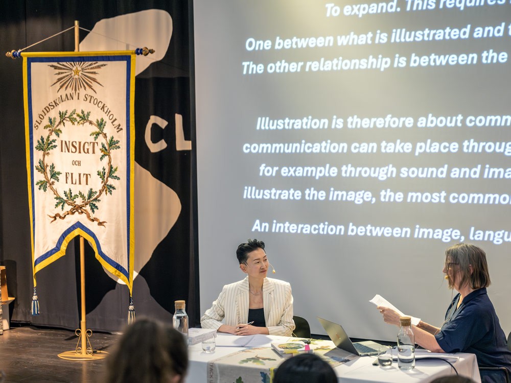 Cecilia Flumé and her opponent sitting behind a table